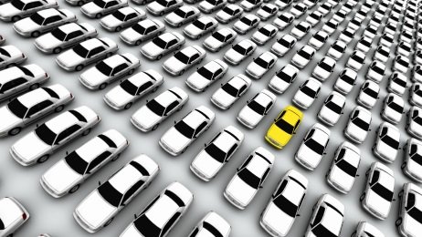 One yellow lemon car standing out among a lineup of white vehicles — NC lemon law attorney representing defective vehicle owners